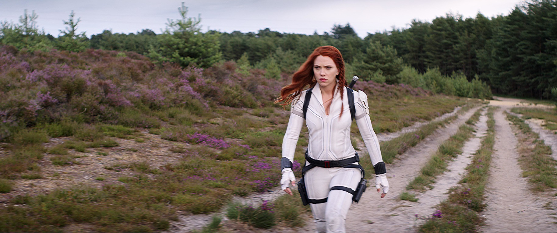 Action shot of Scarlett Johansson as Natasha Romanoff walking through Hankley Common, in Black Widow