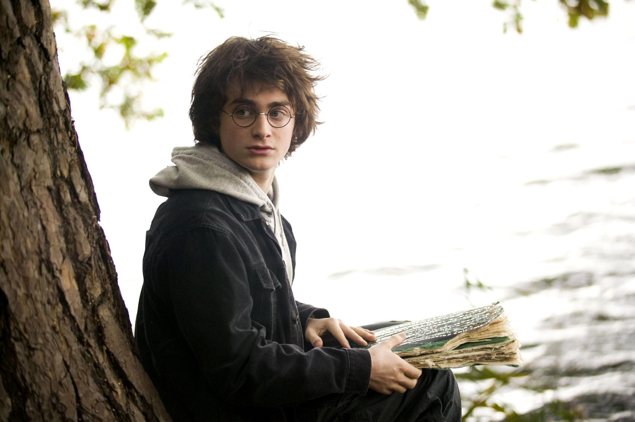 Daniel Radcliffe as Harry Potter, sat reading a book under a tree by Virginia Water Lake