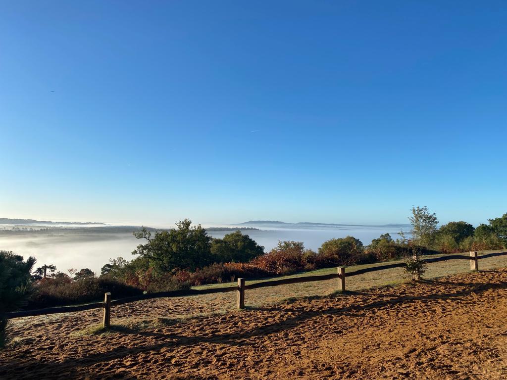 Blue sky with misty landscape view at St Martha's Hill